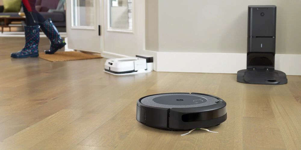 Ein schwarzer Roomba mit einem wei&szlig;en im Hintergrund